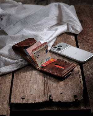Dogaart Athen brown waxed pull up leather wallet open showing multiple banknotes with iPhone 17 Pro comparison