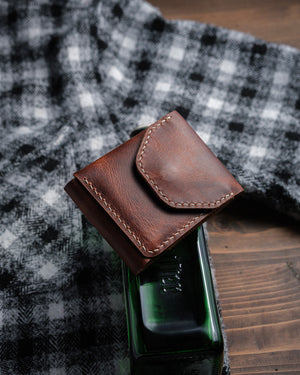 Dogaart Athen brown waxed pull up leather wallet positioned on desktop with careful lighting to show texture