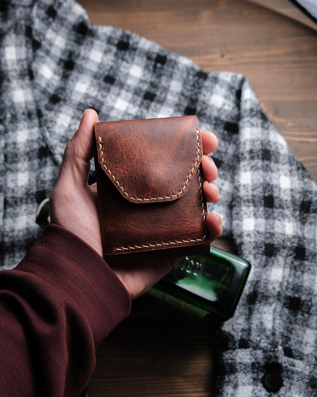Dogaart Athen brown waxed pull up leather wallet held closed in palm showing compact size and portability