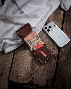 Dogaart Athen brown waxed pull up leather wallet open on desk next to iPhone 17 Pro for size reference