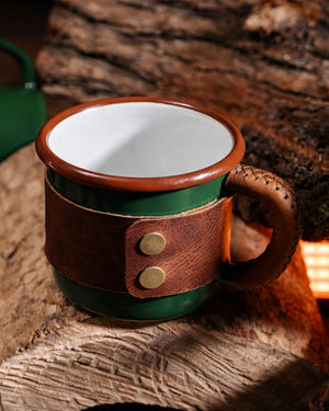 Close-up detail of stainless brass snap fasteners securing genuine leather wrap on green enamel camping mug