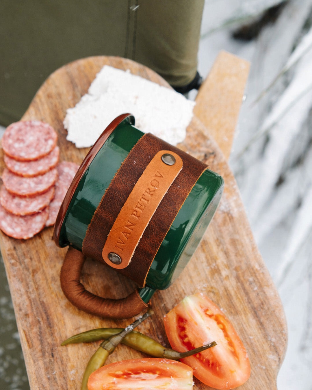 Top-down view of branded green enamel mug featuring personalized leather wrap and premium 330ml construction