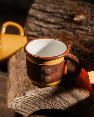 Close-up of Dogaart yellow mug showing brass snap fasteners and stainless steel hardware construction details
