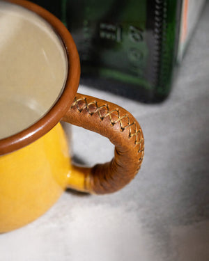 Detailed view of Dogaart yellow mug handle showcasing precise leather stitching and wrapping craftsmanship