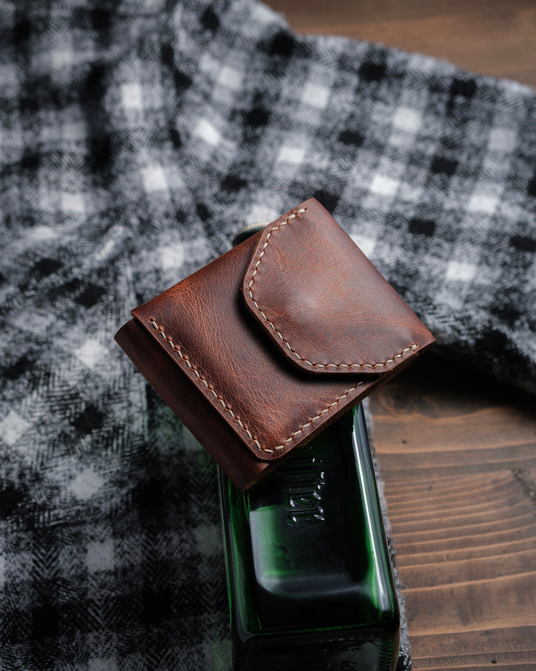 Dogaart Athen brown waxed pull up leather wallet positioned on desktop with careful lighting to show texture