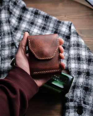 Dogaart Athen brown waxed pull up leather wallet held closed in palm showing compact size and portability