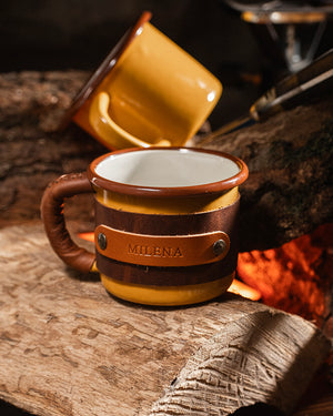 Front view of Dogaart yellow enamel mug with leather handle wrap showing custom name engraving detail