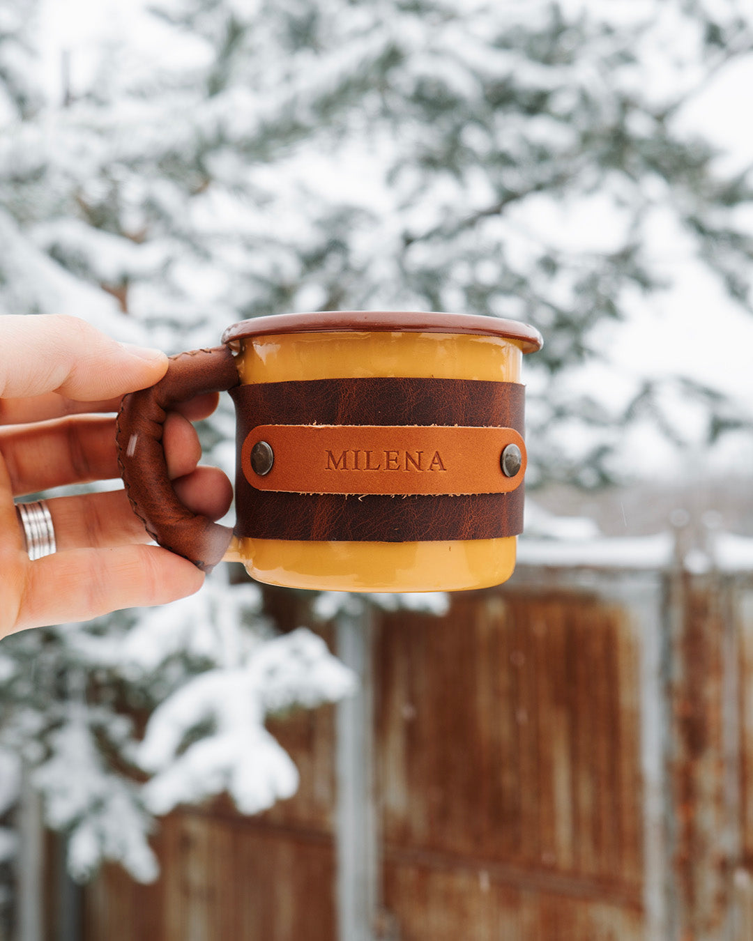 Person holding Dogaart yellow enamel mug demonstrating comfortable leather-wrapped handle grip and ergonomics