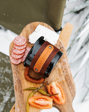 Gift mug featuring embossed leather sleeve with custom branding, premium craftsmanship, angled top view