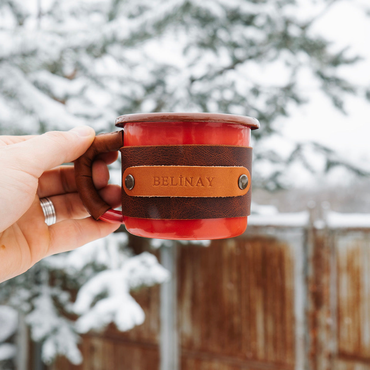 Adventure cup enamel mug with leather sleeve, comfortable grip for hiking, in-hand view