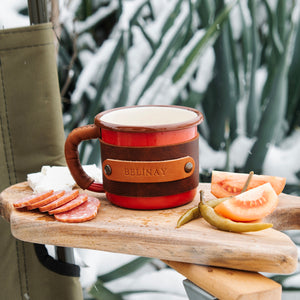 Hiking enamel mug with brass hardware and leather sleeve, outdoor adventure gear, front view
