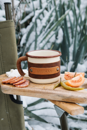 Rustic camping mug with leather wrap perfect for outdoor adventures, wooden surface setting